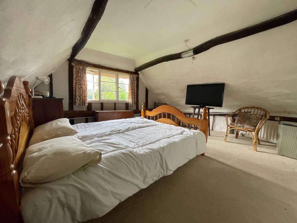 Lot: 145 - DETACHED COTTAGE IN HERTFORDSHIRE VILLAGE LOCATION - Bedroom 1 with exposed beams and window to side